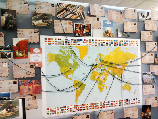 Postcard display on a library with a world map